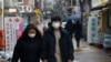 FILE - A couple wearing masks walks on a street during the COVID-19 pandemic in Seoul, South Korea, Dec. 13, 2020. The country saw a record number of marriages last year, possibly because weddings were delayed due to social restrictions during the pandemic. 