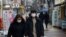 FILE - A couple wearing masks walks on a street during the COVID-19 pandemic in Seoul, South Korea, Dec. 13, 2020. The country saw a record number of marriages last year, possibly because weddings were delayed due to social restrictions during the pandemic. 
