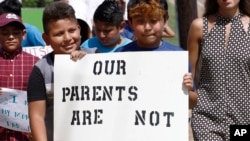 FILE - Children of mainly Latino immigrant parents hold signs in support of them and those individuals picked up during an immigration raid, during a protest march to the Madison County Courthouse in Canton, Miss., Aug. 11, 2019.