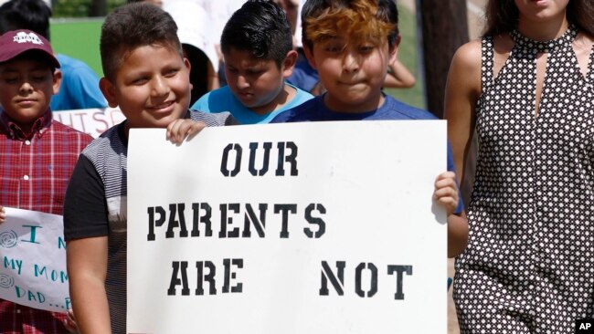 Con em các di dân gốc Mỹ Latin cầm biểu ngữ kêu gọi ủng hộ cha mẹ của các em bị truy quét trong cuộc trấn áp di dân bất hợp pháp tháng 8/2019.