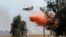 An air tanker drops a load of fire retardant while fighting a large grass fire, July 27, 2015, in Elverta, California.