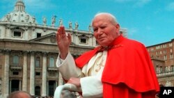 FILE - In this file photo taken on April 23 1997, Pope John Paul II waves to faithful as he crosses St. Peter's square at the Vatican.