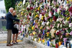 President Joe Biden and first lady Jill Biden visit a memorial wall covered in flowers and photos of the missing, July 1, 2021, after a condo tower collapsed in Surfside, Fla.