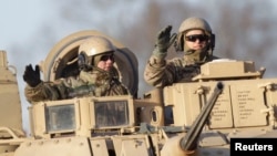 FILE - U.S. soldiers are seen atop a military vehicle deployed in Latvia, in Riga Nov. 18, 2014.