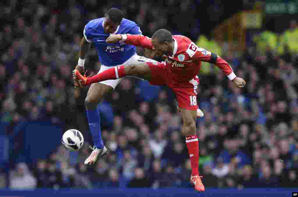 Sylvain Distin, kiri, dari klub Everton berusaha merebut bola dari Loic Remi dari klub Queens Park Rangers dalam pertandingan sepak bola Liga Utama Inggris di Stadium Taman Goodison, Liverpool, Inggris.