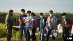 Para migran diproses oleh Patroli Perbatasan Amerika Serikat setelah melintasi perbatasan AS-Meksiko ke Amerika Serikat di Penitas, Texas pada 8 Juli 2021. (Foto: AFP)