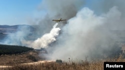 Pesawat pemadam kebakaran menyemprotkan bahan penghambat api untuk memadamkan kebakaran akibat roket yang ditembakkan dari Lebanon ke Israel, utara Israel, 17 Agustus 2024. (Foto: REUTERS/Avi Ohayon)