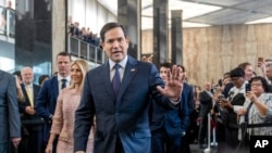 Secretary of State Marco Rubio greets people as he arrives to speak to State Department staff followed by his family, at the State Department, Jan. 21, 2025, in Washington. 