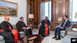 In this photo released on the official Facebook page of the Syrian Presidency, Syrian President Bashar al-Assad, right, meets Cardinal Peter Turkson, second right, in Damascus, Syria, July 22, 2019. 