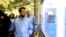 FILE - Iran's Minister of Information and Communications Technology Mohammad Javad Azari Jahromi looks at The Nahid-1 domestically-built satellite at a space center. Photo provided Aug. 31, 2019. (Iran's Information and Communications Technology via AP)