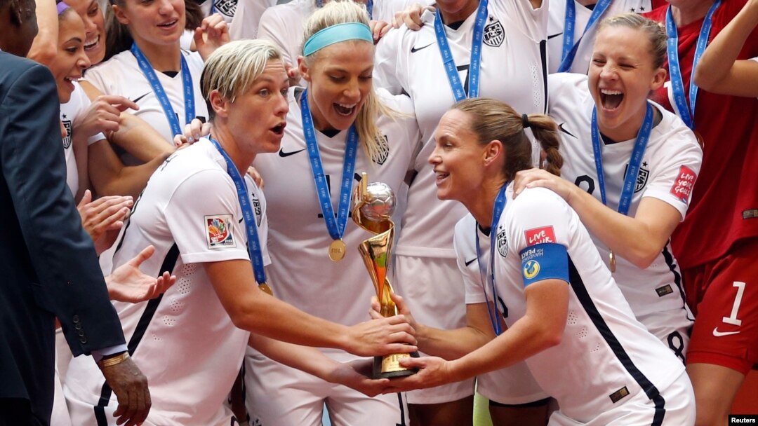 United States forward Abby Wambach (20) and United States defender Christie Rampone (3) hoist the trophy after defeating Japan in the final of the FIFA 2015 Women's World Cup at BC Place Stadium, July 5, 2015.