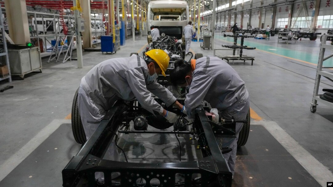 Pekerja merakit kerangka sasis minibus di pabrik manufaktur Tenglong Automobile Co. di Xiangyang, provinsi Hubei, China tengah (foto: dok). 