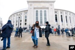 FILE - People line up at a COVID-19 vaccination site at Yankee Stadium, Feb. 5, 2021, in the Bronx borough of New York.