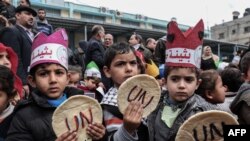 FILE - Palestinian children hold bread patties during a protest against aid cuts, outside the United Nations' offices in Khan Yunis in the southern Gaza Strip on Jan. 28, 2018.
