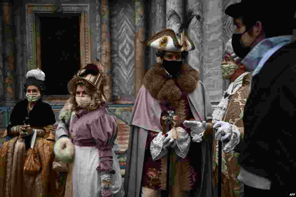 People wearing carnival costumes parade across St. Mark&#39;s Square in Venice, Italy, Feb. 6, 2021, despite the carnival is cancelled due to the Covid-19 pandemic.