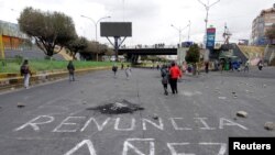 Personas pintaron en la calle la frase "Renuncia Áñez", en referencia a la presidenta interina de Bolivia, Jeanine Áñez, en una de las calles bloquedas en demanda de que se realicen las elecciones presidenciales en Bolivia. 11 de agosto de 2020.