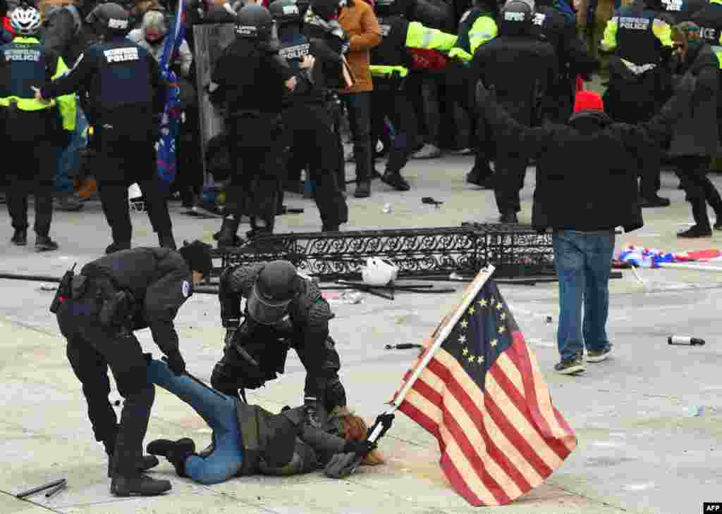 Police detain a person as supporters of President Donald Trump protest outside the U.S. Capitol, Jan. 6, 2021, in Washington, D.C.