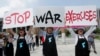 FILE - Protesters shout slogans while holding signs to oppose planned joint military exercises between South Korea and the United States near the U.S. Embassy in Seoul, South Korea, Aug. 5, 2019.