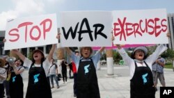 FILE - Protesters shout slogans while holding signs to oppose planned joint military exercises between South Korea and the United States near the U.S. Embassy in Seoul, South Korea, Aug. 5, 2019.