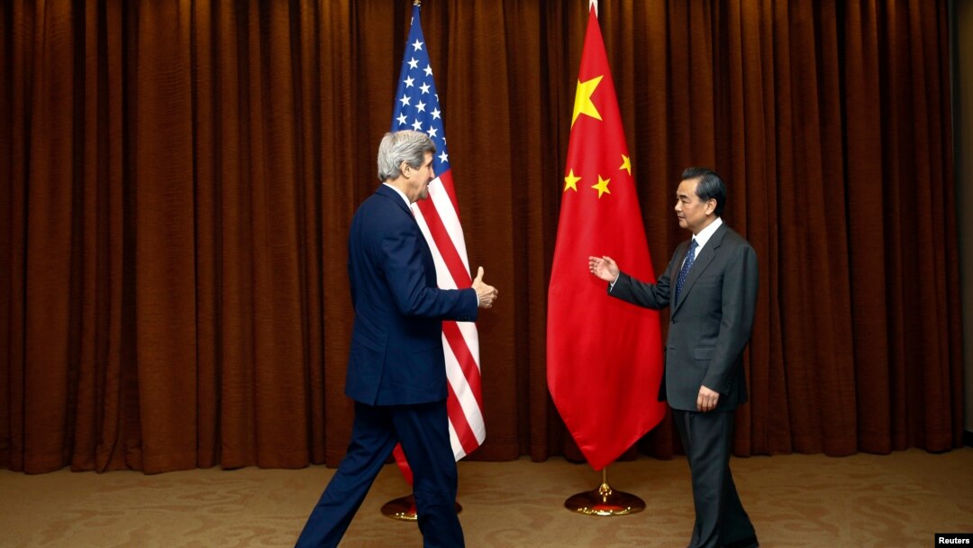 Menteri Luar Negeri China Wang Yi (kanan) menyambut Menteri Luar Negeri AS John Kerry dalam kunjungan di Beijing (14/2). (Reuters/Diego Azubel)