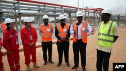 L’ex-président du Ghana, John Dramani Mahama, accompagné de George Sipa-Adjah Yankey, à droite, chef de la Ghana National Gas Company, et Emmanuel Kofi Buah, à gauche, ministre de l'Énergie et du Pétrole, s'adressent aux journalistes lors d’une visite à l