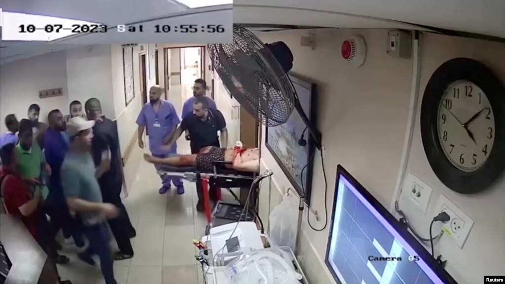 资料图片：以色列军方于2023年11月19日公布的一段截屏视频显示，安全摄像头拍摄了他们所说的哈马斯伊斯兰武装分子在10月7日袭击当天将一名人质从以色列带到希法医院的画面。 （Israel Defense Forces/Handout via REUTERS）(photo:VOA)