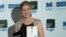 New Zealand writer Eleanor Catton poses after being announced the winner of the Man Booker Prize for Fiction, holding her prize and her book for the photographers, in central London, Oct. 15, 2013. 