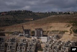 FILE -This photo shows a construction site of new housing projects in the West Bank Israeli settlement of Givat Ze'ev, June 18, 2023.