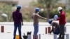 کارگران ساختمانی با ماسک های حفاظتی در حال کار در دوبی در امارات متحده عربی. ۱۴ آوریل ۲۰۲۰