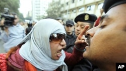 An Egyptian activist shouts at anti-riot policemen who block the way leading to the journalists syndicate in downtown Cairo, Jan 26 2011