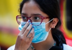 A teen wears a medical mask as a precaution against the spread of the new coronavirus, during an outing in Mexico City, Feb. 29, 2020.