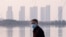 FILE - In this Jan. 30, 2020 file photo, a man wears a face mask as he stands along the waterfront in Wuhan in central China's Hubei Province.