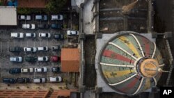 Los feligreses permanecen en sus autos durante una misa dominical en autocine montada por el padre Jonathan González, en la Iglesia de Nuestra Señora de Coromoto, en el barrio El Paraíso de Caracas, el 25 de octubre de 2020.