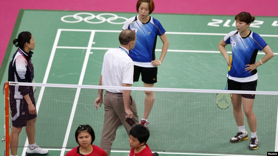 Wasit berbicara dengan para pemain Korea Selatan (berpakaian biru) dan atlet-atlet Indonesia (merah) dalam Olimpiade London 2012.