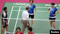 Wasit berbicara dengan para pemain Korea Selatan (berpakaian biru) dan atlet-atlet Indonesia (merah) dalam Olimpiade London 2012.