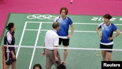 Tournament referee Torsten Berg (3rd R) speaks to players from South Korea (in blue) and Indonesia (in red) during their women's doubles group play stage Group C badminton match during the London 2012 Olympic Games at the Wembley Arena July 31, 2012.