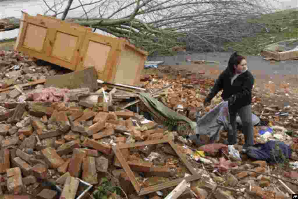 Hannah Rechel, from Dent, Ohio, helps recover personal items from debris after a tornado hit Friday in the village of Moscow, Ohio, Sunday, March 4, 2012.