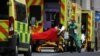 Para petugas medis memindahkan seorang pasien dari ambulans di Royal London Hospital di tengah pandemi virus corona (COVID-19) di London, Inggris, Minggu, 10 Januari 2021. 
