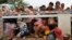 Cambodian migrant workers get off Thai truck upon arriving at international border crossing in Poipet, Cambodia, June 17, 2014.