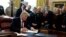 President Donald Trump signs the first veto of his presidency in the Oval Office of the White House, March 15, 2019, in Washington. Trump issued the veto to protect his emergency declaration for border wall funding.