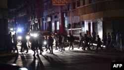 People cross a street during a power cut in Caracas on March 7, 2019.