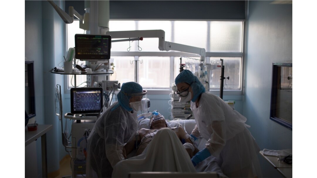Health care workers assist a COVID-19 patient in the intensive care unit at the Joseph Imbert Hospital Center in Arles, southern France, April 5, 2020.