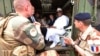 Le président français Emmanuel Macron (au centre) avec le président malien de l'époque Ibrahim Boubacar Keita (à droite) à l'intérieur d'un véhicule militaire alors qu'ils rendent visite aux troupes françaises à Gao, dans le nord du Mali, le 19 mai 2017.