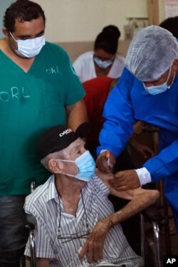 A nurse administers an AstraZeneca COVID-19 vaccine to an elderly patient at "Santo Domingo" senior home Asuncion, Paraguay, Apr. 10, 2021.