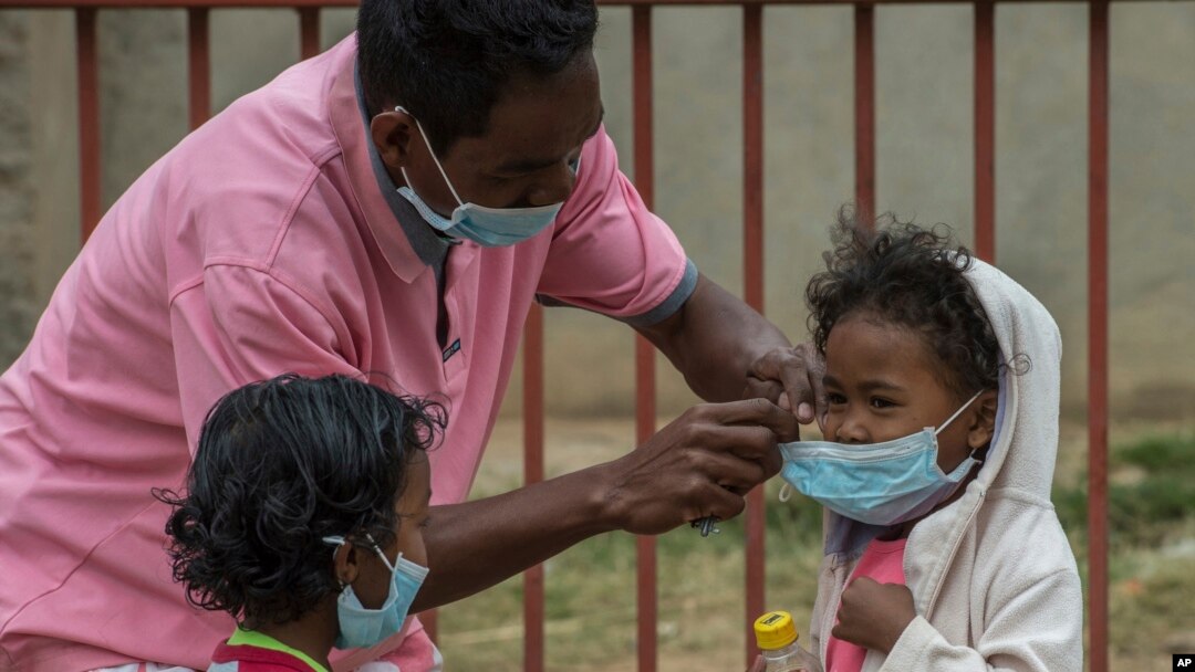Face masks are placed on children in Antananarivo, Madagascar, Oct. 3, 2017. Authorities in Madagascar are struggling to contain an outbreak of the plague that so far has killed 89 people.