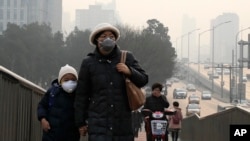 Seorang perempuan dan anaknya mengenakan masker di Beijing, China yang penuh dengan polusi udara (foto: dok). China dan India memiliki udara terburuk di dunia. 