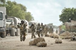 FILE - Soldiers with the African Union Mission in Somalia march through the town of Golweyn in Somalia's Lower Shabelle region, August 30, 2014, in this handout picture released by the African Union-United Nations Information Support Team.