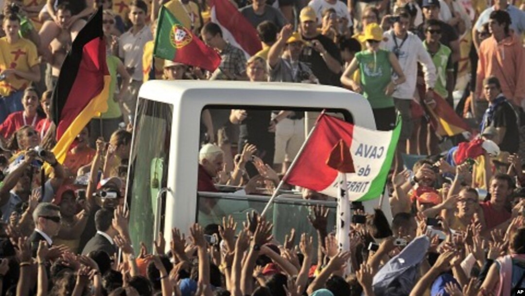Pilgrims greet Pope Benedict XVI in his vehicle as he arrives at Cuatro Vientos, near to Madrid, Spain, August 21, 2011