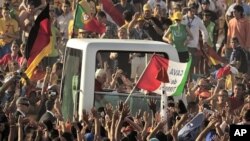 Pilgrims greet Pope Benedict XVI in his vehicle as he arrives at Cuatro Vientos, near to Madrid, Spain, August 21, 2011