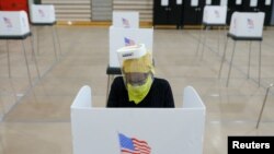 Una mujer votando en un centro de votación de Baltimore, en el estado de Maryland, el 28 de abril de 2020, en medio de la crisis sanitaria del coronavirus.